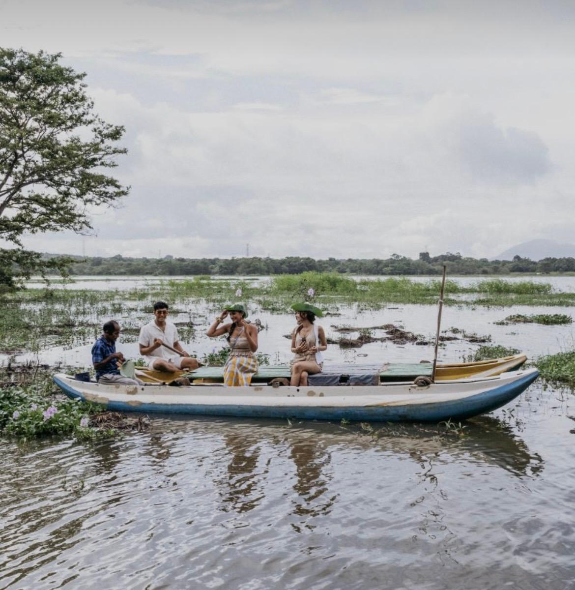 A small wooden canoe with visitors and a local guide on the Kandalama lake